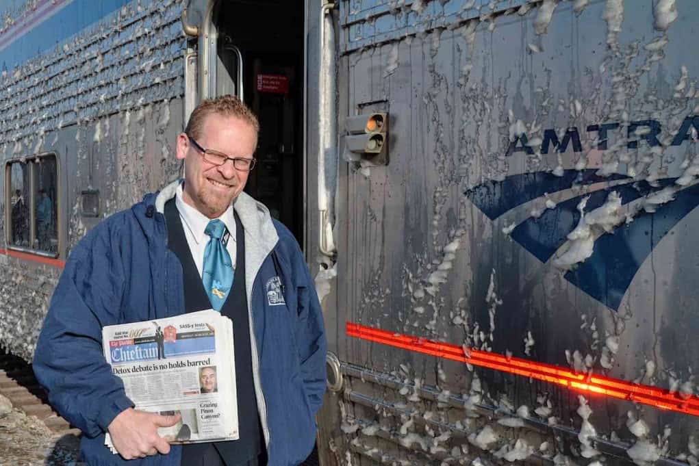 amtrak attendant holding morning newspapers