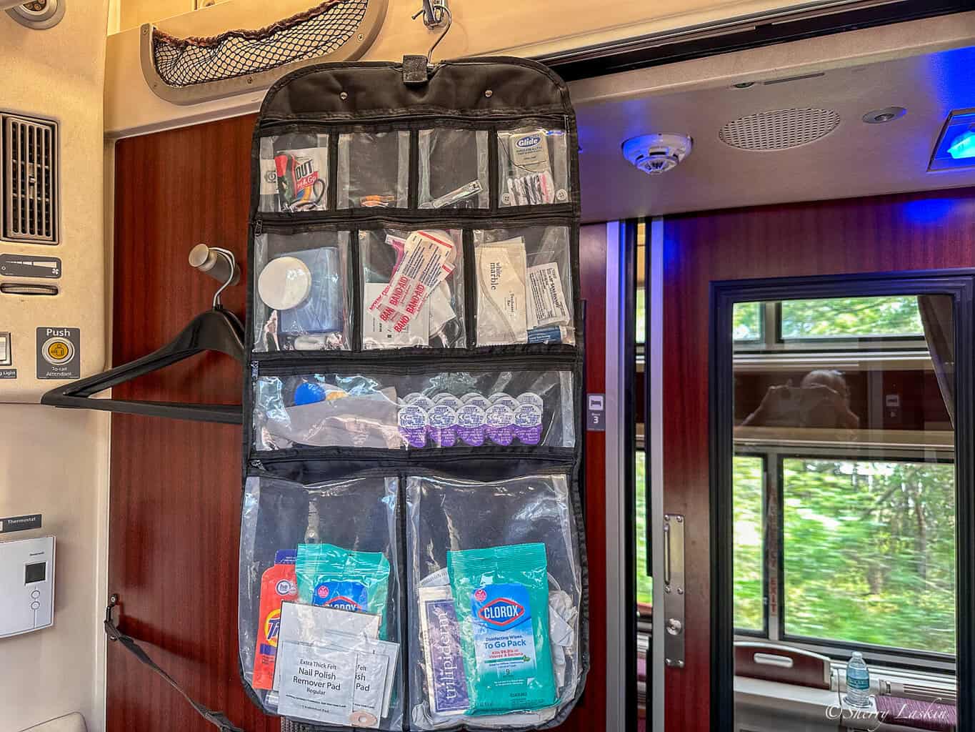 Hanging cosmetic bag with several sections that show some of the items I packed as toiletries.