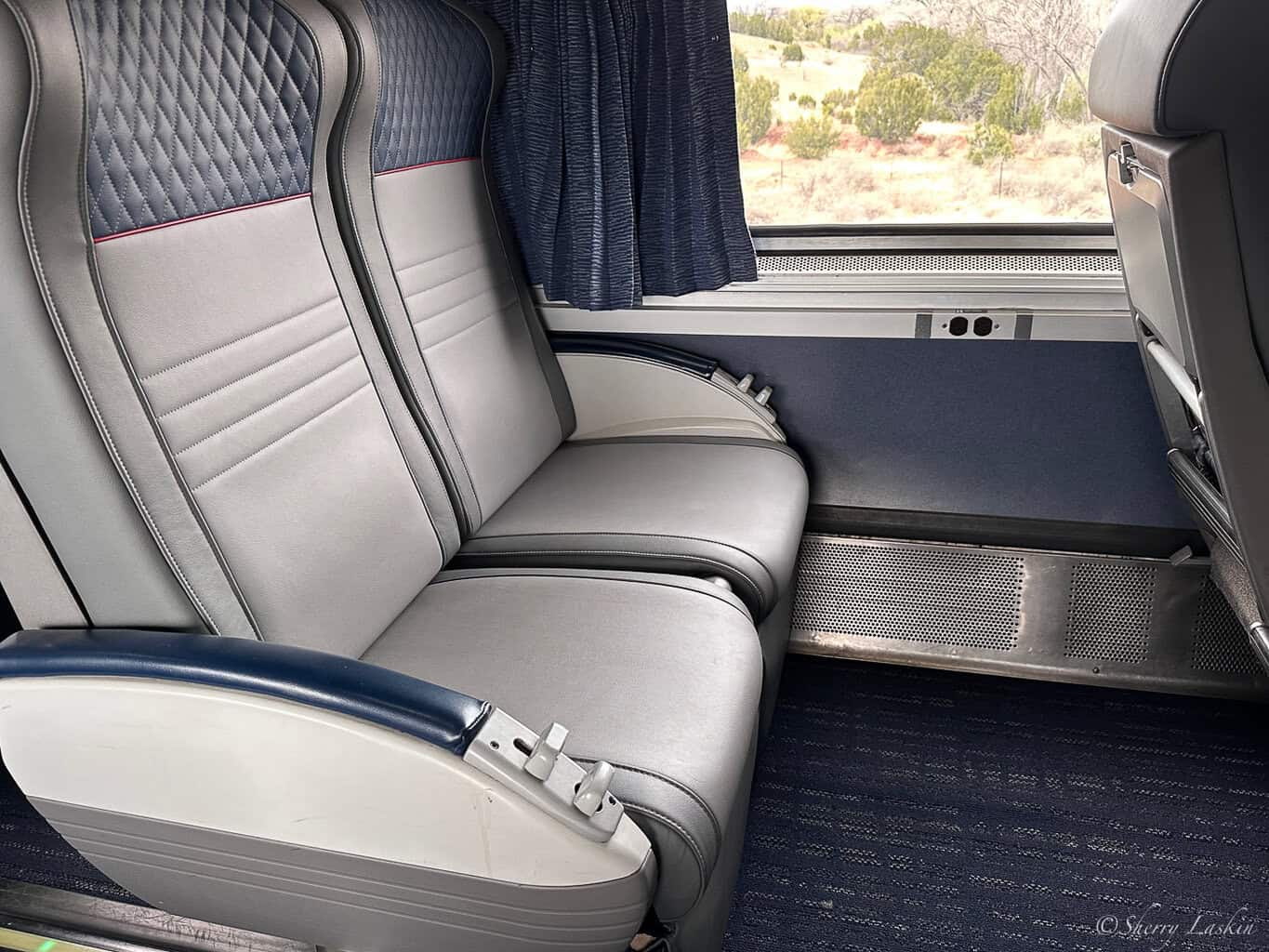 New Amtrak coach seats in light gray and navy blue colors.