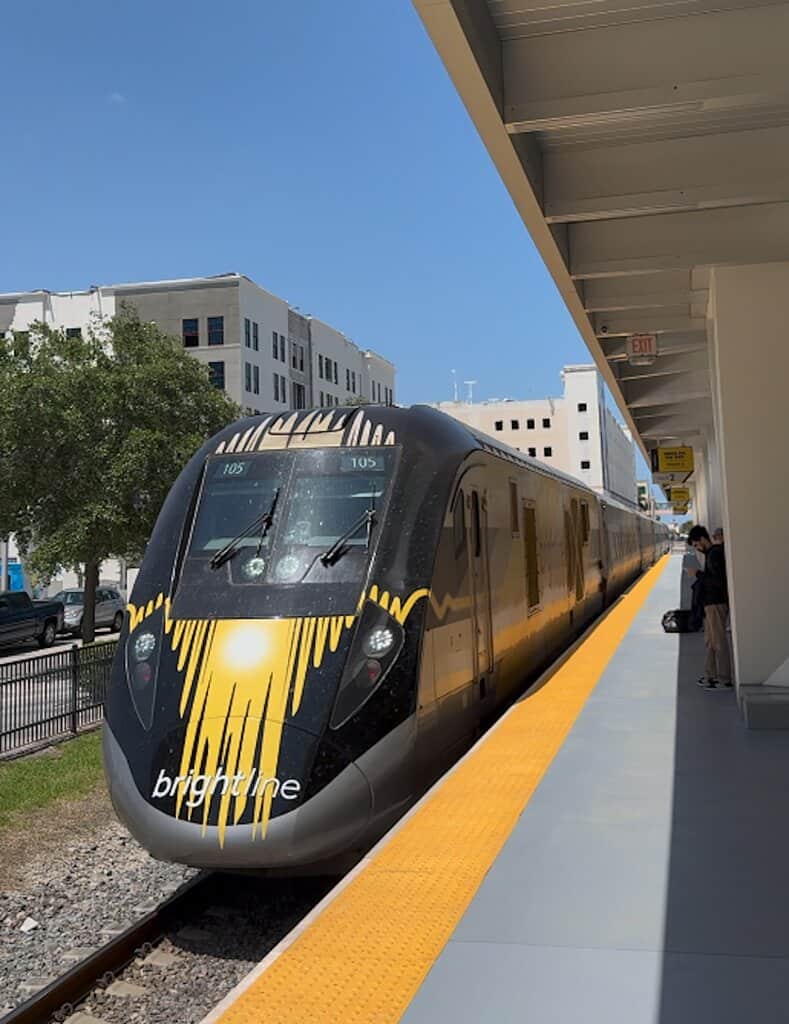 Brightline Train stops at the West Palm Beach station, as people wait to board.