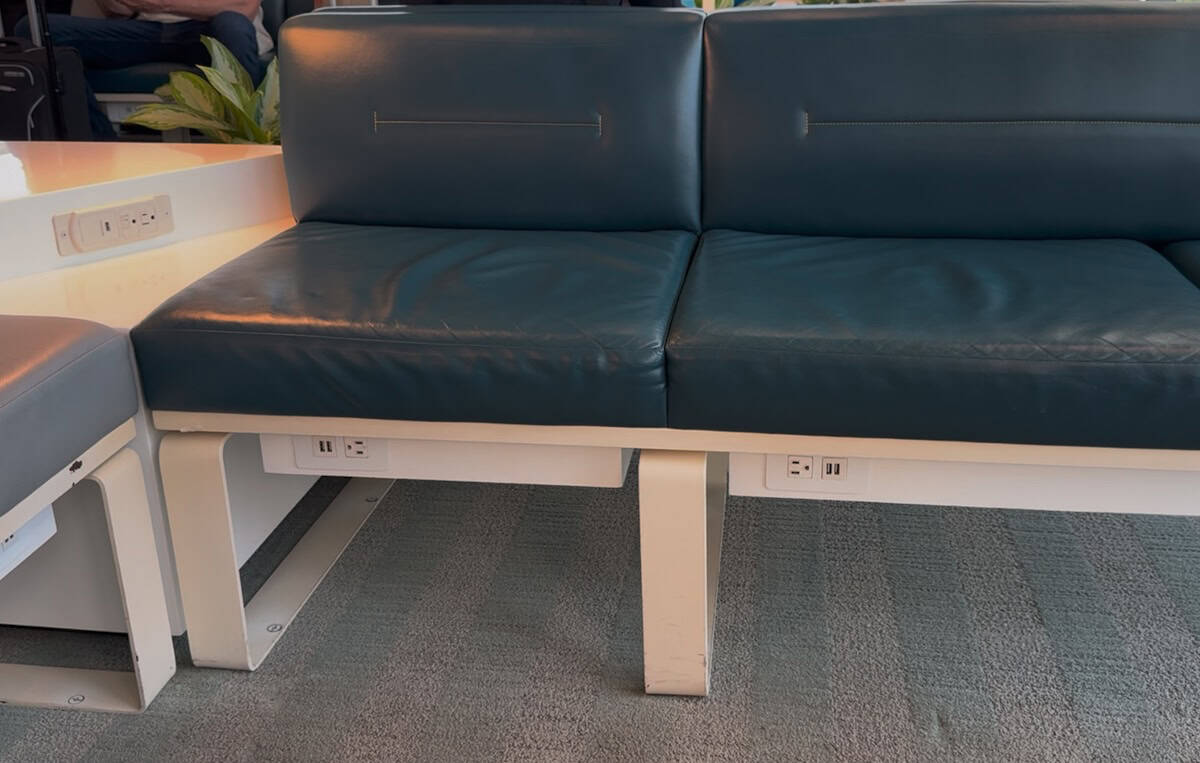 Smart class blue leather couch seating with electric and USB ports in easy reach.