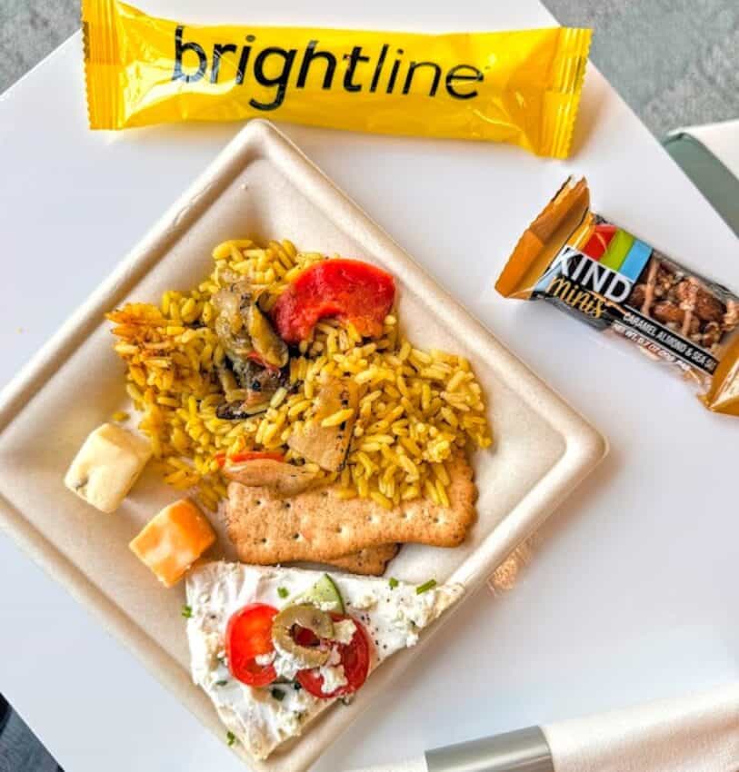 My meal in Premium lounge; a selection of Spanish rice, cheeses, crackers and a Kind snack bar.